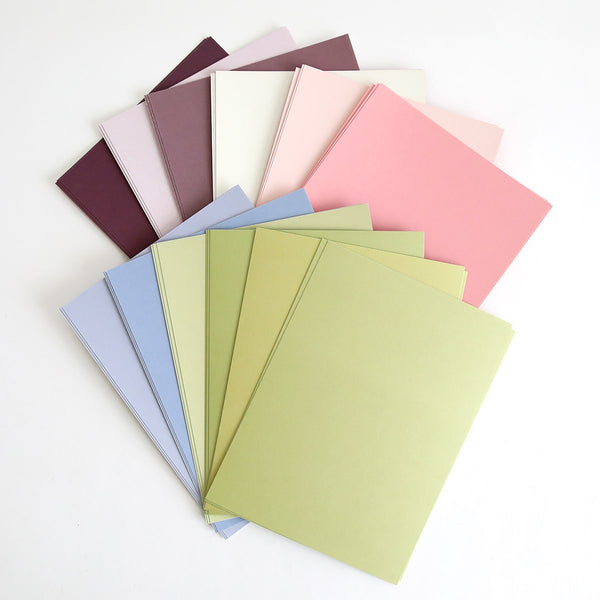 a bunch of different colors of paper on a white surface.