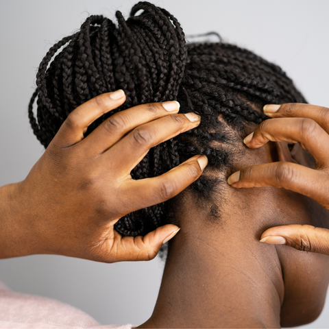 Woman with box braids scratching scalp