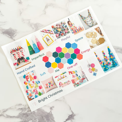 A Holchester Designs moodboard entitled Bright Christmas is printed on an A4 and is lying on a marble tabletop.  The board features a number of small hexagons of different bright colours in the centre, an is surrounded by various images of christmas decorations, ornaments and soft furnishings which are also vibrant colours.  The board also has some words written around it such as 'playful' and 'soft'.