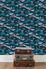three old leather suitacases are stacked on a wooden floor infront of a wall which is covered in the Migrating Cranes repeating pattern as wallpaper.