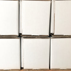 side view of two rows of white cardboard mug packaging boxes.