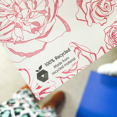 A corner of the Spring Forward wrapping paper which has a small printed section including a recycled logo and the words 100% recycled made from recycled material.