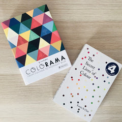 two books - Colorama and Secret lives of colour - are lying side by side on a wooden table top