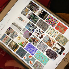 An ipad is leaning on a knee, with the screen full of a Pinterest board of animal print and related patterns, fashion etc.