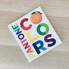 Pantone Colours book - a book for children - is lying on a wooden table top