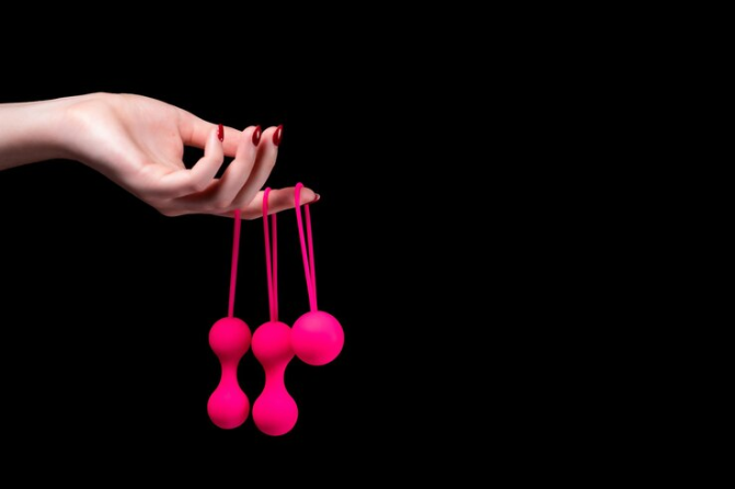 Woman39s hand holds pink Kegel balls Ben Wa balls 