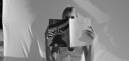 Woman hiding her face with a VOGUE magazine while wearing a  vibrator panties