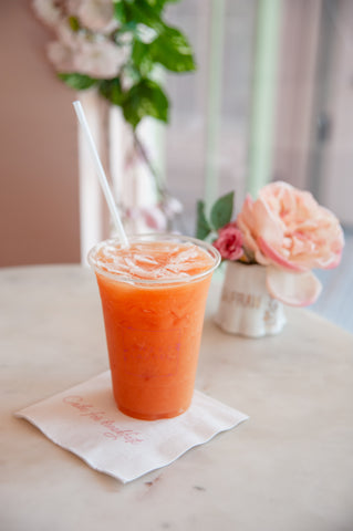 guava grapefruit auga fresca on a napkin with flowers on the side