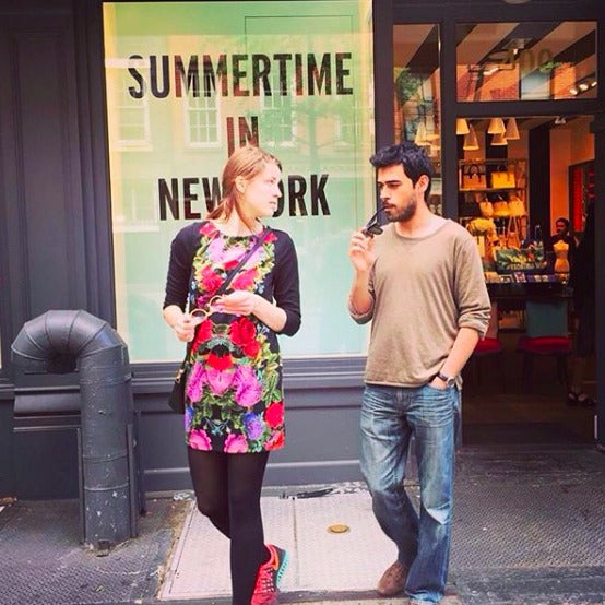 Lisa and Emre in front of a "Summertime in New York" banner