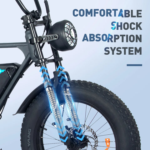 A detailed view of the front part of a black electric bicycle, focusing on its shock absorption system. The bike features a sophisticated front suspension with blue and silver shock absorbers, indicated by blue arrows showcasing the movement and absorption. Above the suspension, the bike's headlight is visible, and the phrase 'COMFORTABLE SHOCK ABSORPTION SYSTEM' is prominently displayed, emphasizing the bike's design for a smooth and stable ride