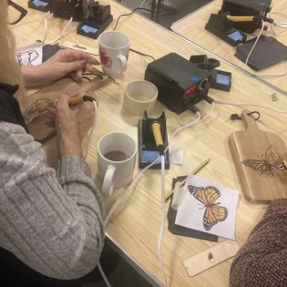 craft class learning to use pyrography machine to create artwork
