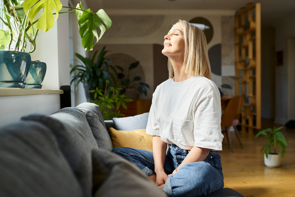 woman sat in living room by house plants
