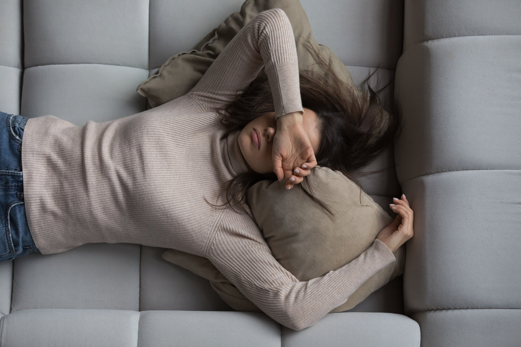 Woman on a sofa who looks tired and exhausted