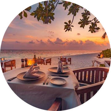 outdoor-restaurant-at-the-beach-table-setting-at-tropical-beach-restaurant-led-light-candles-and-wooden-tables-chairs-under-beautiful-sunset-sky-sea-view-luxury-hotel-or-resort-restaurant-photo-modified.png__PID:c67d4847-0999-40fc-a48f-f4ea774299a9
