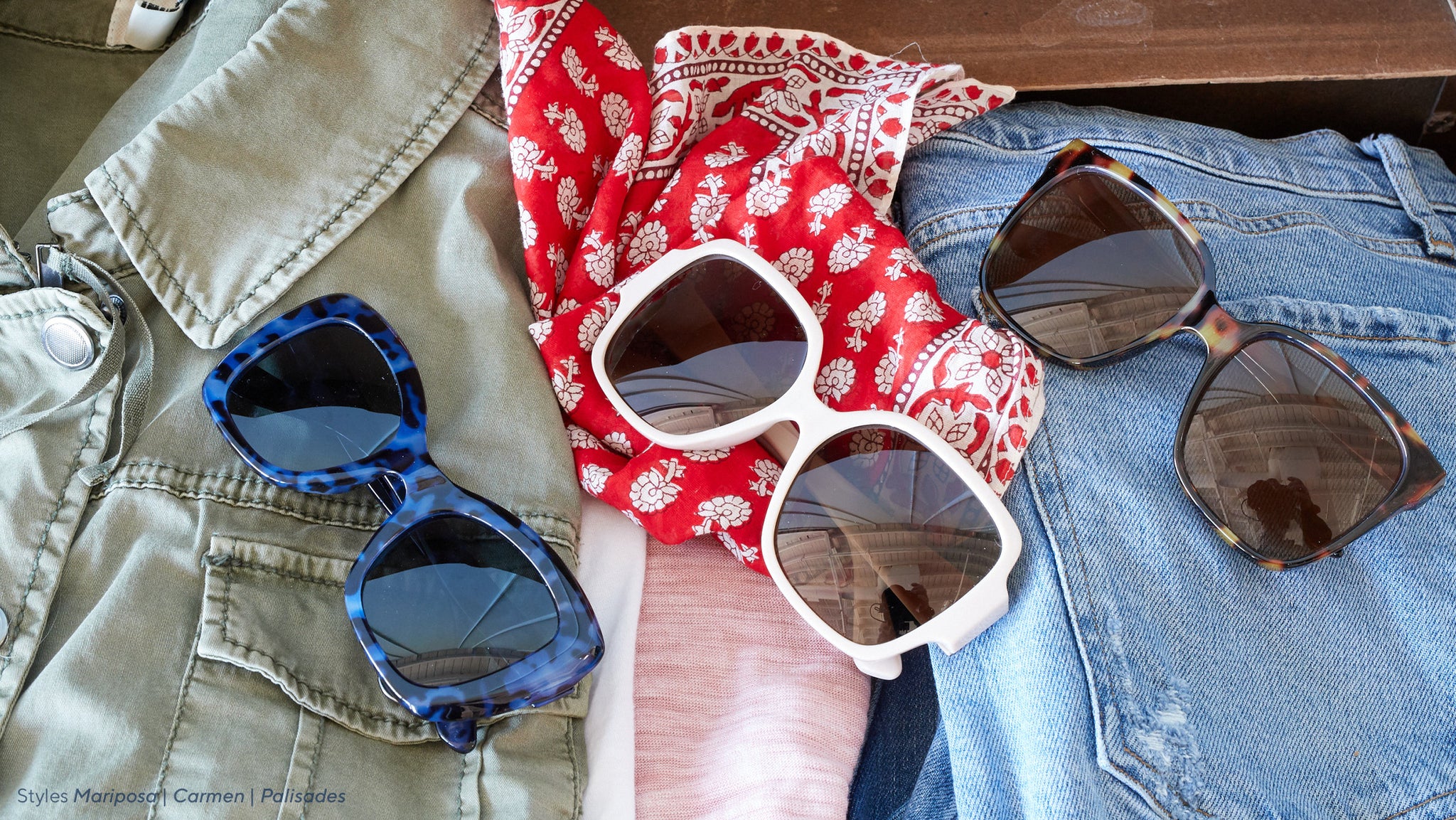 Peepers sunglasses styled on clothes packed in a suitcase