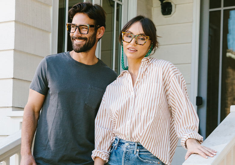 Man and Woman Standing Outside Wearing Men's Peepers Reading Glasses Vaughn and Women's Blue Light Glasses Sterling in Tortoise Shell