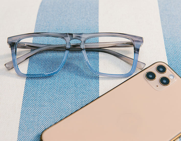 Peepers Reading Glasses Swagger Laying Flat On Striped Towel Next To Phone