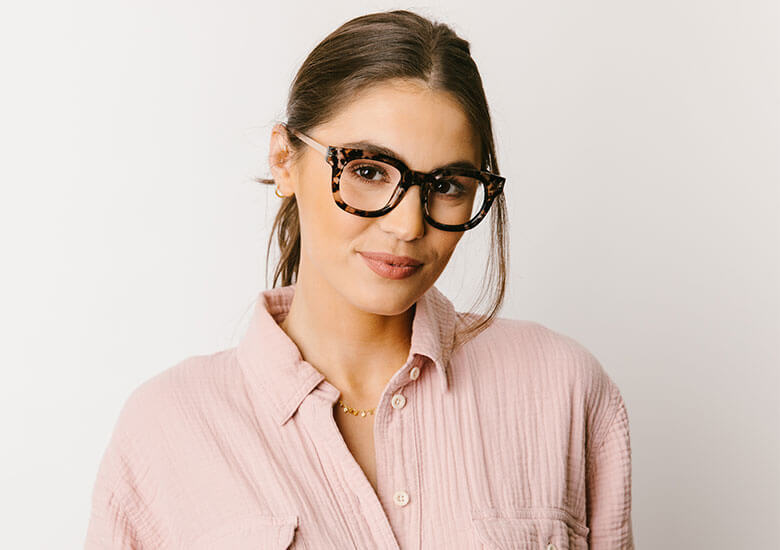 Woman standing in front of plain backdrop wearing Peepers Reading Glasses Celeste