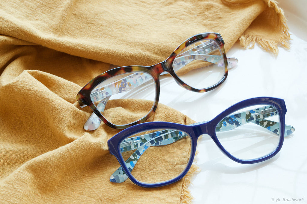 Brushwork Peepers blue light reading glasses folded flatlay on mustard gold cloth