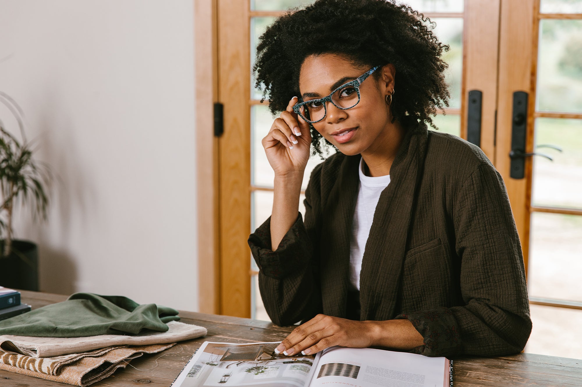 Woman wearing Peepers reading glasses while working from home