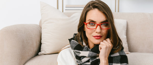 Woman in scarf wearing red Peepers reading glasses