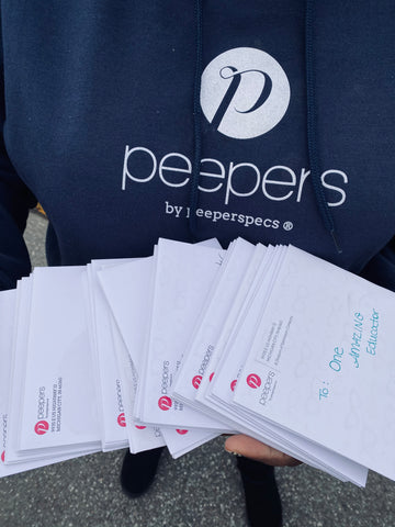 Peepers Employee Holding Envelopes for Donation to Multiple Teachers and Schools