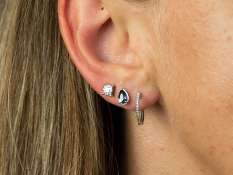 Woman wearing a selection of silver gemstone earrings