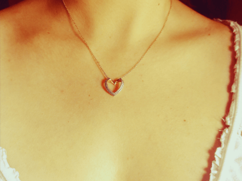 A woman wearing a rose gold cz heart necklace