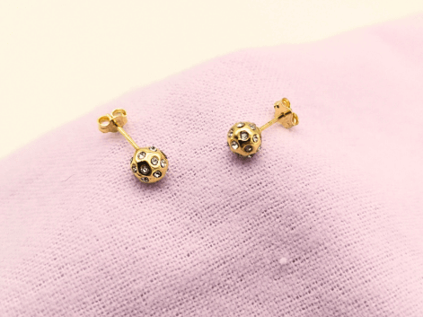 gold stud earrings on a purple napkin