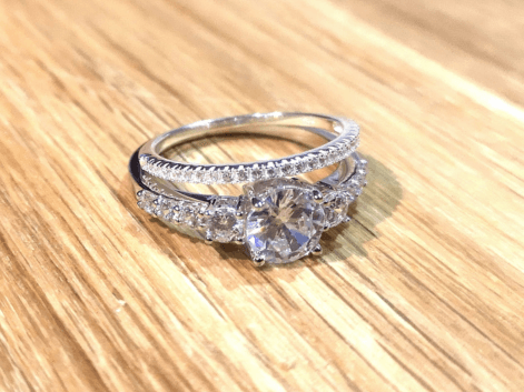 Diamond engagement ring and diamond eternity ring on a wooden table.png__PID:21891192-2e91-46f6-a940-4e3e84bc0e84