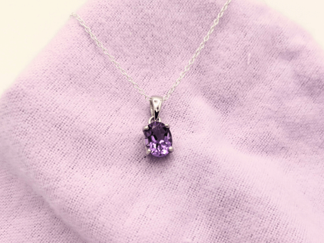 Oval amethyst necklace on a purple napkin