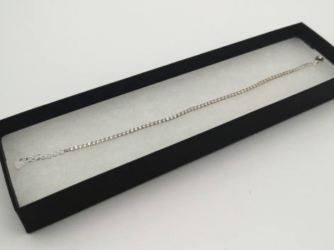 Tennis bracelet in a jewellery box on a white background