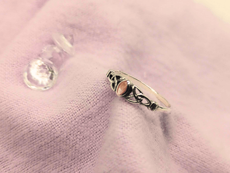 silver pink mother of pearl celtic knot ring on a purple napkin