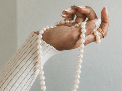 Woman holding a beaded pearl necklace