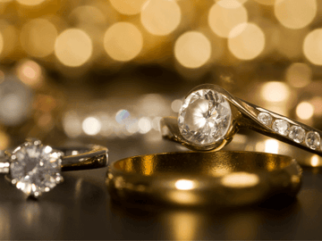 Gold and diamond rings on a black background