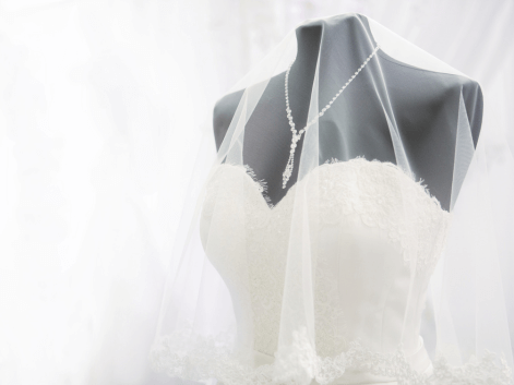 A whte wedding dress on a lack mannequin