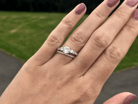 Woman wearing a diamond 3 stone engagement ring and a diamond eternity ring