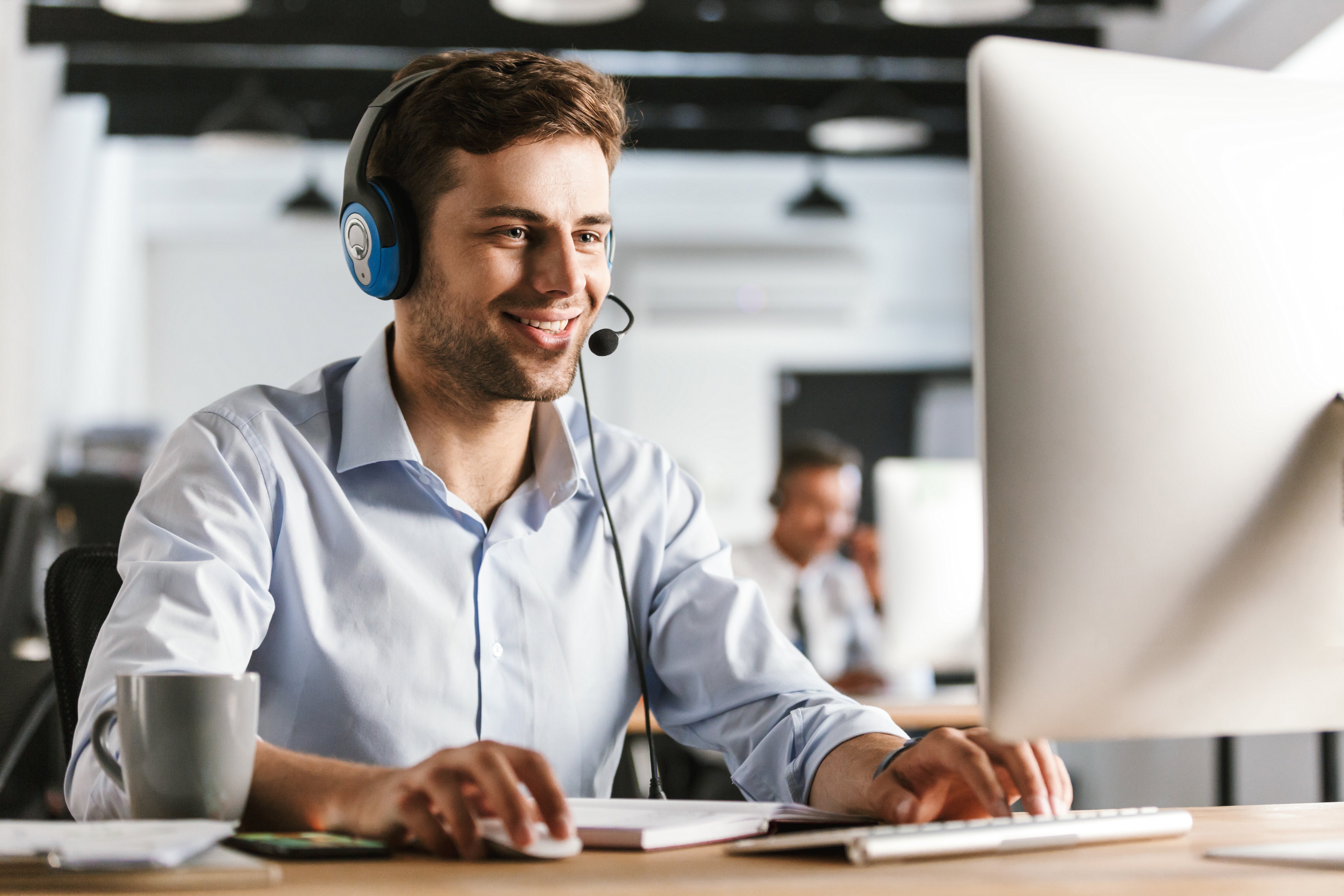 photo-young-worker-man-20s-wearing-office-clothes-headset-smiling-talking-with-clients-call-center.jpg__PID:53dd6a72-1036-4ab3-9bd8-51389700a1a1