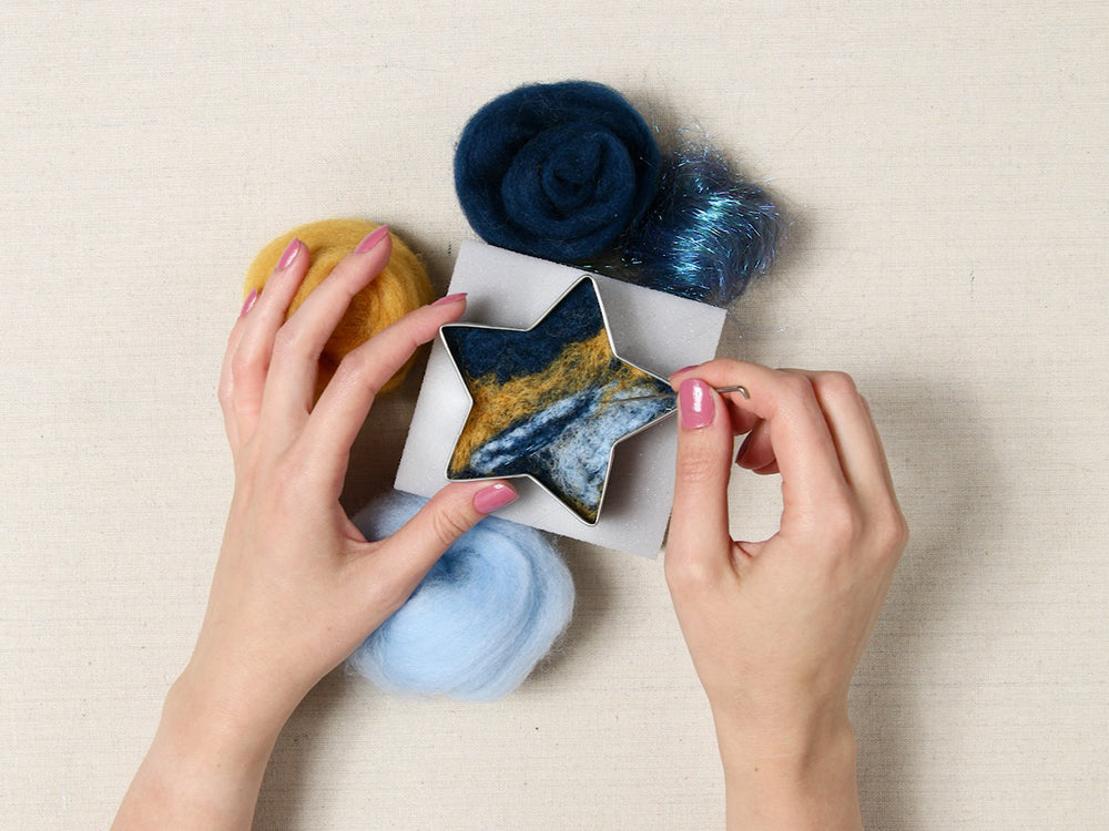 Hands with needle felting supplies