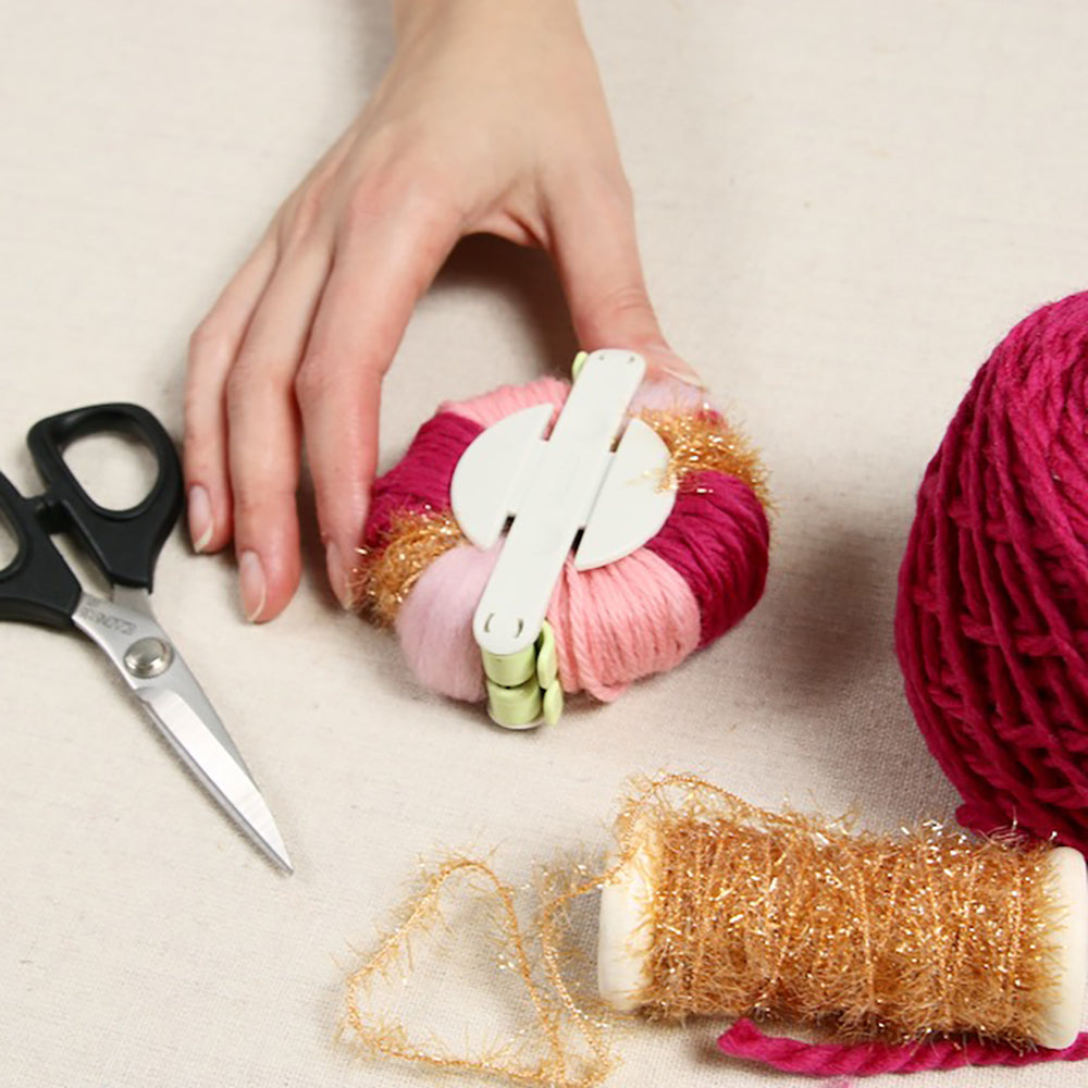 Filling opposite side of pom maker with yarn