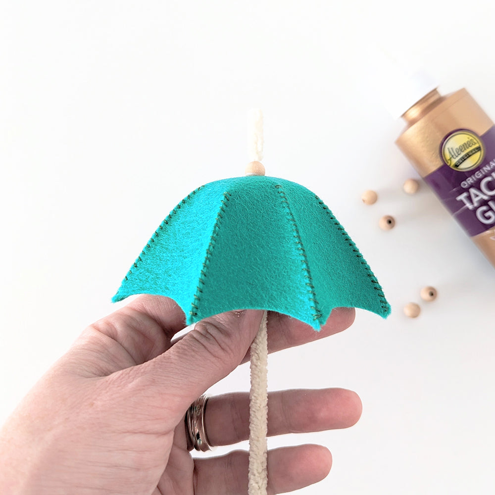 Adding wooden beads to umbrella