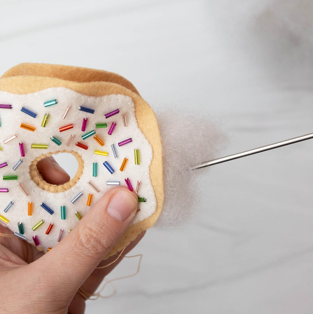 Adding stuffing and stitching donut closed