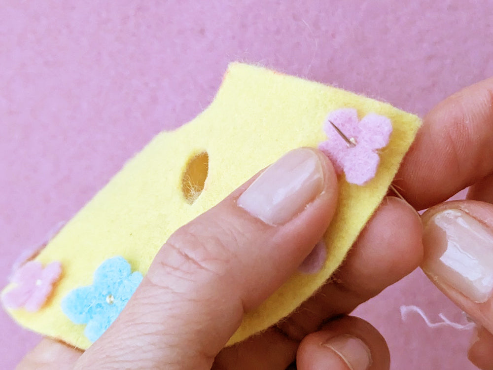 Stitching flowers onto bottom edge of dress