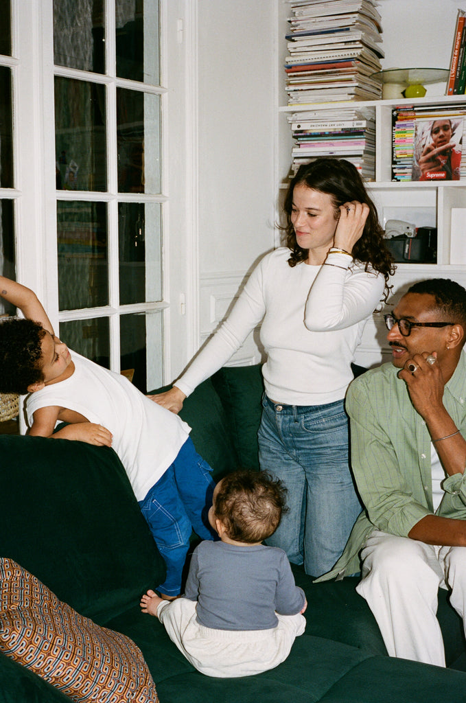 Portrait of the family in their living room with Sarah wearing the white OMEAR Long Sleeve