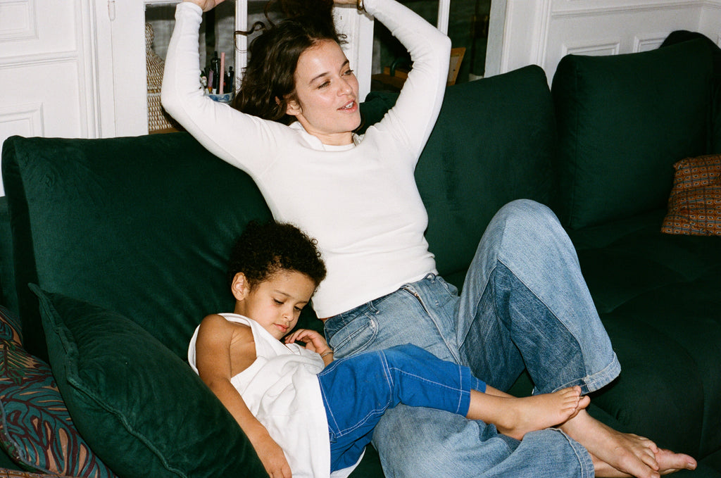 Portrait of Sarah and Eli on the sofa, wearing the OMEAR Long Sleeve in white