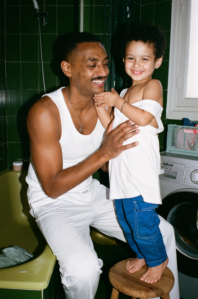 Portrait of Georges and Eli in the bathroom, they are both wearing OMEAR basics in white