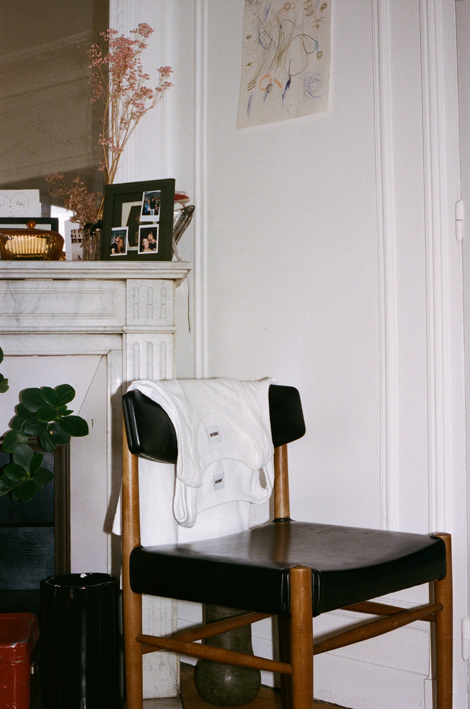 Portrait of Sarah and Georges, a few white OMEAR tank tops placed on a chair in the living room