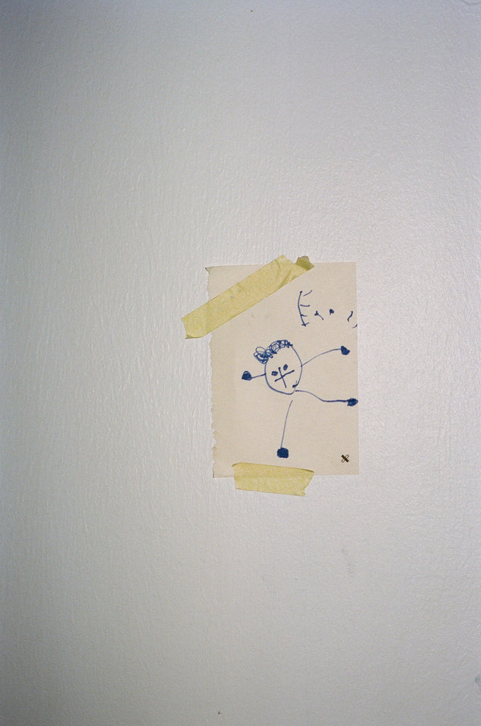 Portrait of Sarah in the children's bedroom, a drawing hanging on the wall