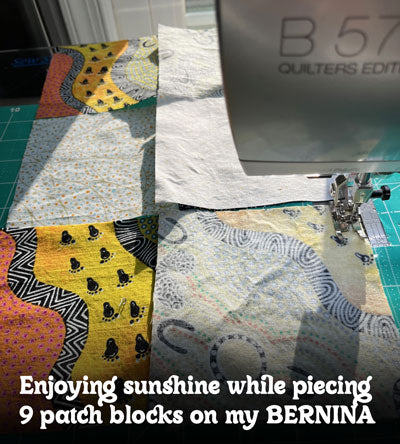Enjoying sunshine while piecing 9 patch blocks on my BERNINA