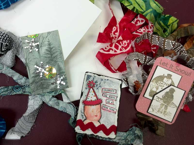 Materials to craft greeting cards using woven fabric strips and Artist Trading Cards